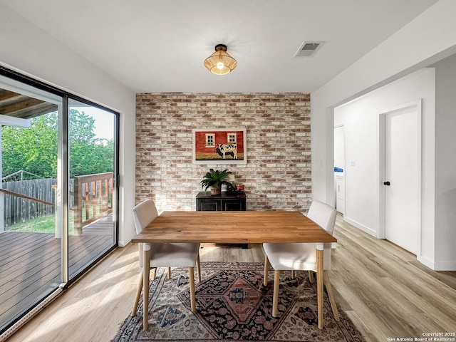 1412 Laurie, Canyon Lake, TX 78133 - dining room featuring light wood finished floors, brick wall, and baseboards