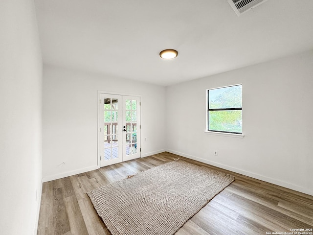1412 Laurie, Canyon Lake, TX 78133 - empty room with french doors, light wood-style floors, and baseboards