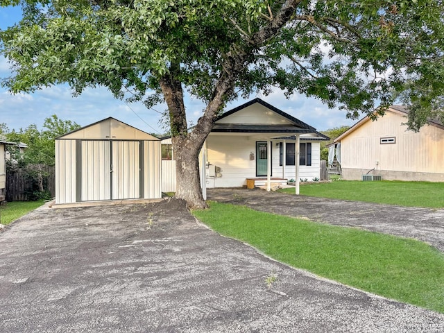 1412 Laurie, Canyon Lake, TX 78133 - view of front of house with a front lawn, an outbuilding, and driveway