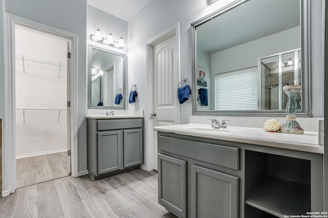 10442 Macarthur, Converse, TX 78109 - bathroom featuring vanity, a stall shower, wood finished floors, and a walk in closet
