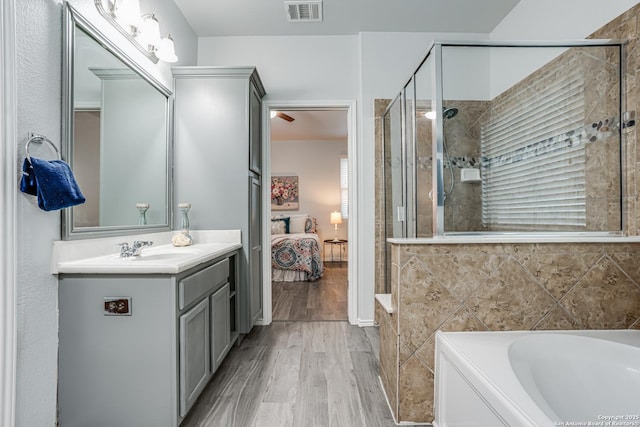 10442 Macarthur, Converse, TX 78109 - bathroom featuring ensuite bathroom, wood finished floors, a bath, vanity, and a shower stall
