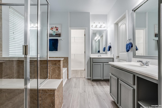 10442 Macarthur, Converse, TX 78109 - bathroom featuring two vanities, a shower stall, a garden tub, and wood finished floors