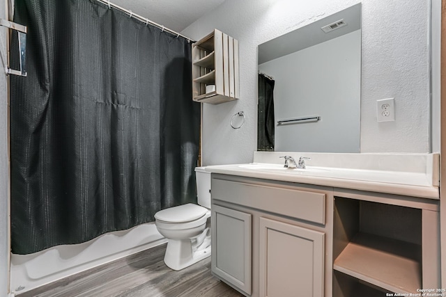 10442 Macarthur, Converse, TX 78109 - full bath with vanity, toilet, wood finished floors, a textured wall, and shower / tub combo