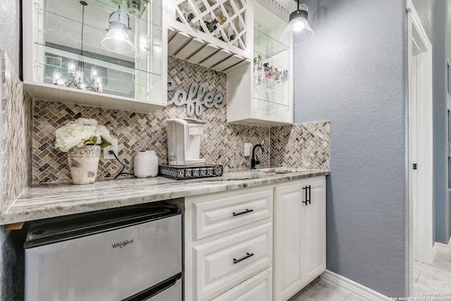 5722 Pioneer Rdg, San Antonio, TX 78245 - kitchen with tasteful backsplash, light stone counters, white cabinetry, and baseboards