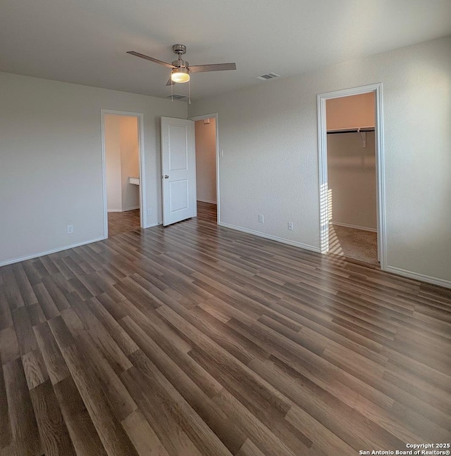 15302 Smoky Honeyeater, San Antonio, TX 78253 - unfurnished bedroom with a walk in closet, baseboards, wood finished floors, and a ceiling fan