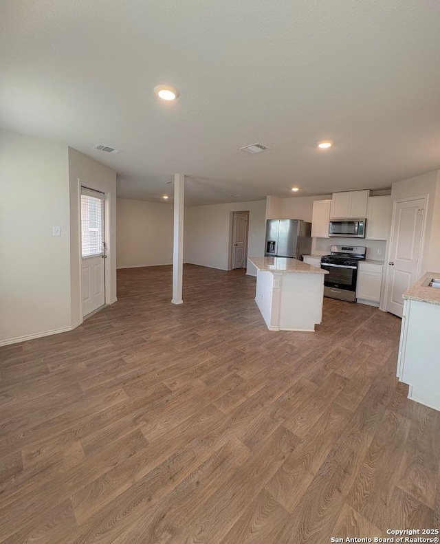15302 Smoky Honeyeater, San Antonio, TX 78253 - kitchen with appliances with stainless steel finishes, open floor plan, light wood-type flooring, a center island, and recessed lighting