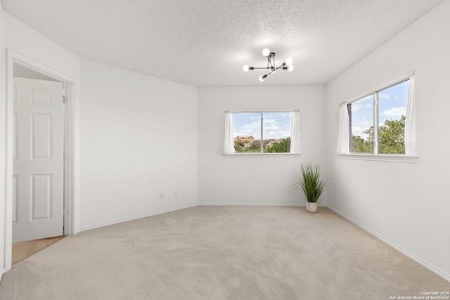 1339 Pecan Sta, San Antonio, TX 78258 - spare room featuring a chandelier, carpet flooring, a textured ceiling, and baseboards