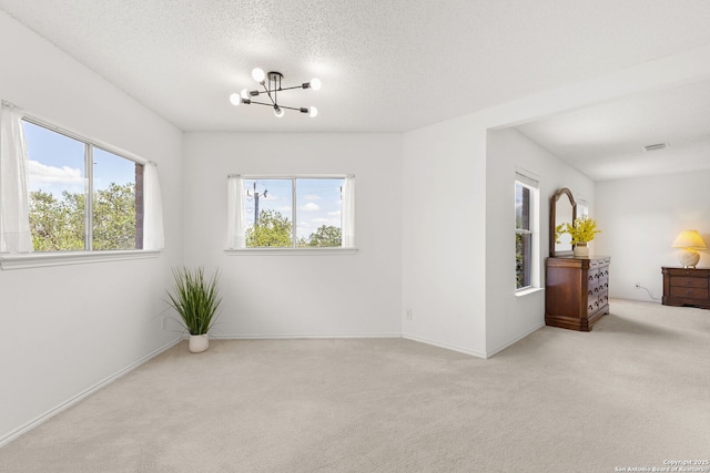 1339 Pecan Sta, San Antonio, TX 78258 - empty room featuring a chandelier, plenty of natural light, carpet flooring, and a textured ceiling