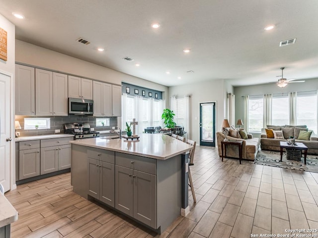 5344 Jasmine, Bulverde, TX 78163 - kitchen featuring gray cabinetry, stainless steel appliances, light wood-type flooring, light countertops, and a sink