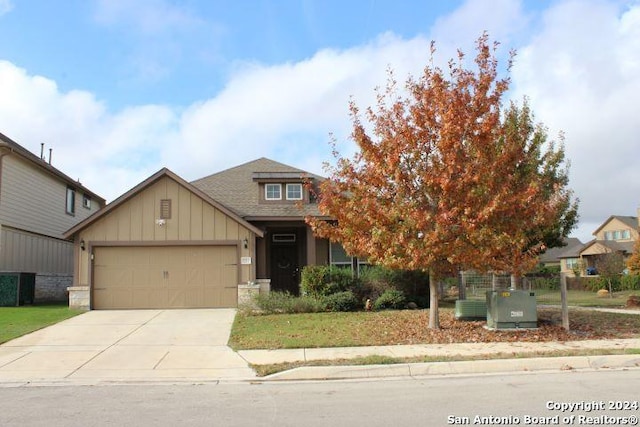 8713 Stackstone, Schertz, TX 78154 - view of front of home with board and batten siding, a garage, concrete driveway, and a shingled roof