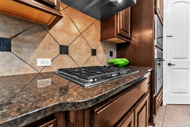 25702 Willard Path, San Antonio, TX 78261 - kitchen with appliances with stainless steel finishes, ventilation hood, tasteful backsplash, dark brown cabinetry, and dark countertops