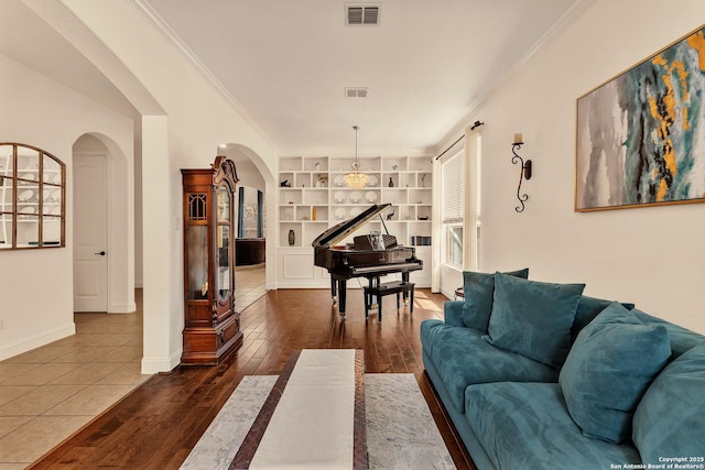 25702 Willard Path, San Antonio, TX 78261 - living room featuring arched walkways, dark wood-style floors, built in shelves, ornamental molding, and baseboards