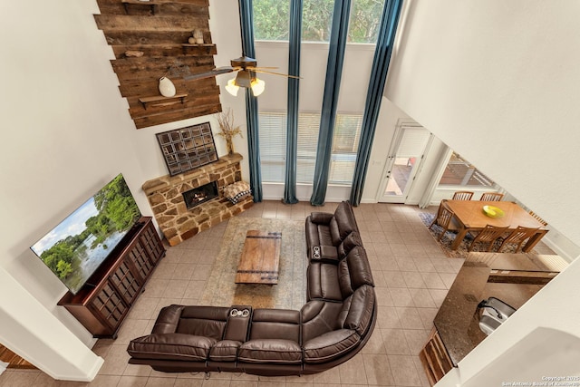 25702 Willard Path, San Antonio, TX 78261 - tiled living area with a ceiling fan, a fireplace, a high ceiling, and baseboards