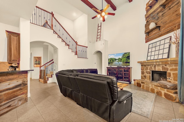 25702 Willard Path, San Antonio, TX 78261 - living area with a high ceiling, arched walkways, a ceiling fan, stairway, and light tile patterned floors