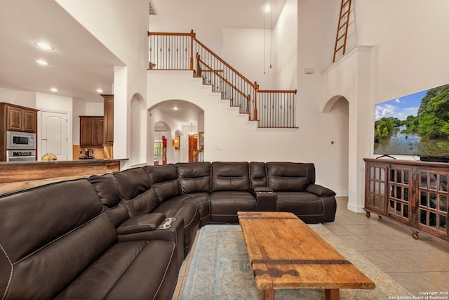 25702 Willard Path, San Antonio, TX 78261 - living room featuring a high ceiling, arched walkways, light tile patterned floors, recessed lighting, and stairs