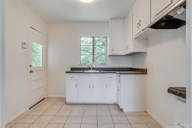 135 Englewood, San Antonio, TX 78213 - kitchen with ventilation hood, dark countertops, white cabinetry, light tile patterned floors, and baseboards
