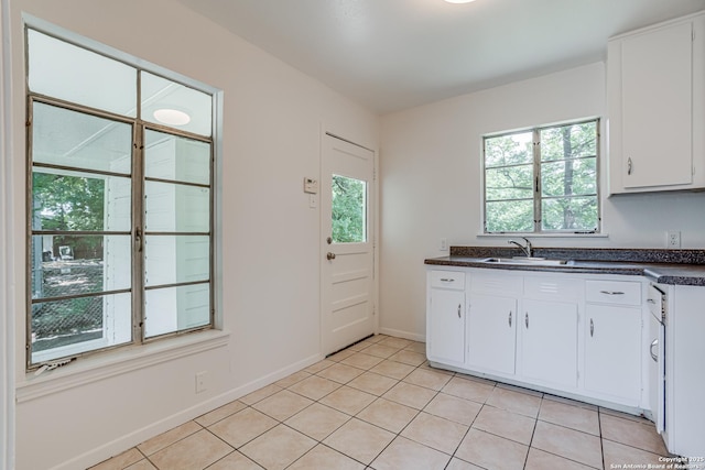 135 Englewood, San Antonio, TX 78213 - kitchen featuring dark countertops, a sink, white cabinets, light tile patterned flooring, and baseboards