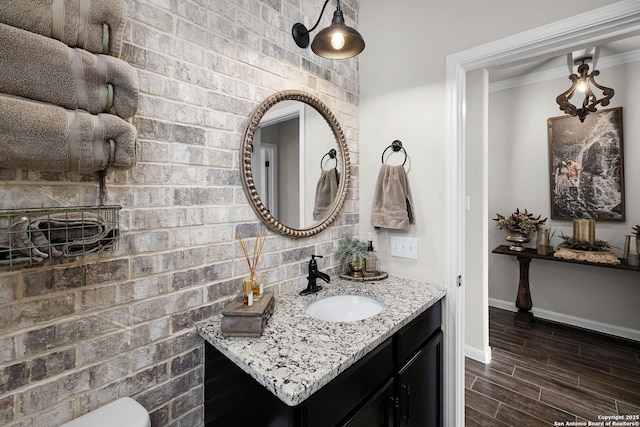 891 Noel, New Braunfels, TX 78130 - bathroom with baseboards, vanity, wood finished floors, ornamental molding, and toilet