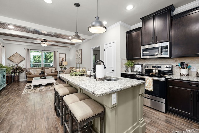 891 Noel, New Braunfels, TX 78130 - kitchen featuring stainless steel appliances, open floor plan, a sink, wood finished floors, and a breakfast bar