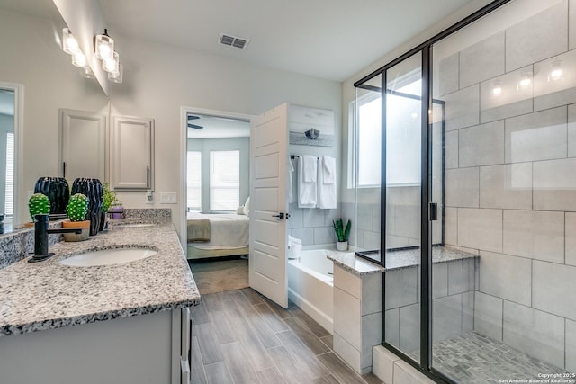 2103 Dalhart, San Antonio, TX 78253 - bathroom featuring double vanity, a garden tub, a shower stall, wood finish floors, and ensuite bathroom