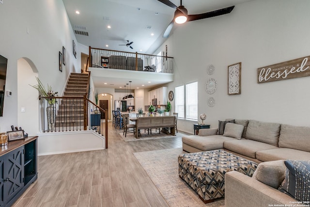 2103 Dalhart, San Antonio, TX 78253 - living room featuring ceiling fan, high vaulted ceiling, stairway, arched walkways, and light wood-style flooring