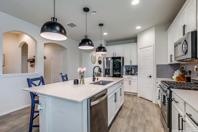 2103 Dalhart, San Antonio, TX 78253 - kitchen with stainless steel appliances, a sink, light wood finished floors, backsplash, and a kitchen breakfast bar