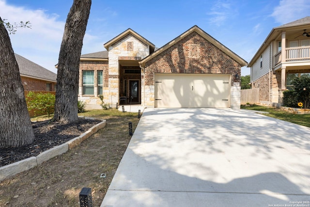 6239 Carriage Cpe, San Antonio, TX 78261 - view of front of home featuring concrete driveway, a garage, brick siding, and stone siding