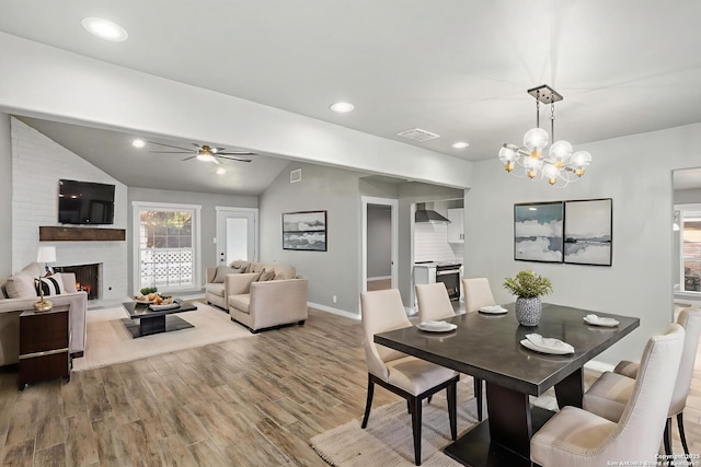2723 Woodline, San Antonio, TX 78251 - dining room featuring a ceiling fan, wood finished floors, a brick fireplace, baseboards, and vaulted ceiling