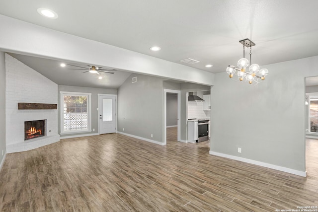 2723 Woodline, San Antonio, TX 78251 - unfurnished living room featuring a ceiling fan, baseboards, a fireplace, wood finished floors, and vaulted ceiling