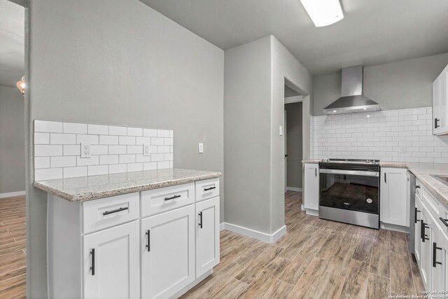 2723 Woodline, San Antonio, TX 78251 - kitchen with stainless steel electric range oven, wall chimney exhaust hood, light wood-type flooring, and decorative backsplash