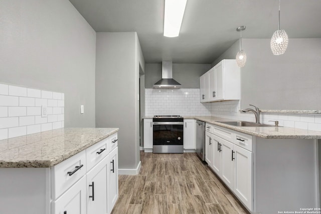 2723 Woodline, San Antonio, TX 78251 - kitchen featuring appliances with stainless steel finishes, a sink, wall chimney exhaust hood, tasteful backsplash, and light wood-style floors