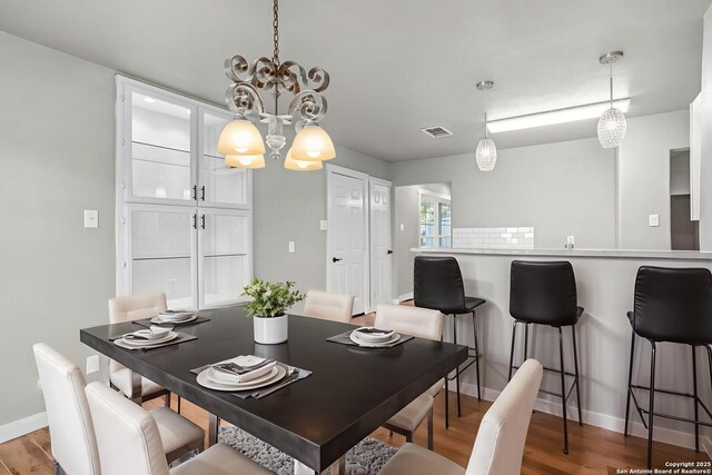 2723 Woodline, San Antonio, TX 78251 - dining area featuring a chandelier, wood finished floors, and baseboards
