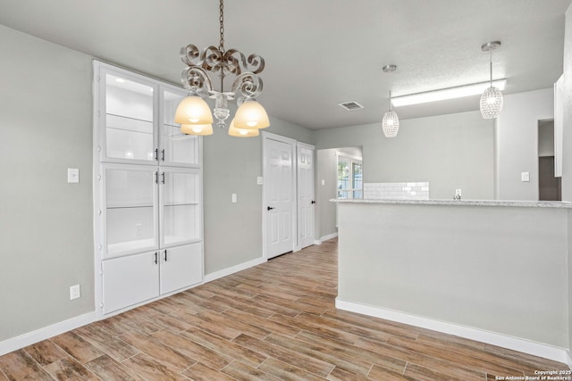 2723 Woodline, San Antonio, TX 78251 - spare room featuring a chandelier, light wood finished floors, and baseboards