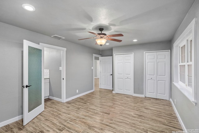 2723 Woodline, San Antonio, TX 78251 - unfurnished bedroom featuring two closets, light wood-style flooring, baseboards, recessed lighting, and ceiling fan