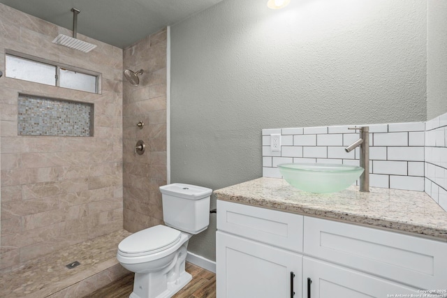 2723 Woodline, San Antonio, TX 78251 - full bath featuring vanity, wood finished floors, tiled shower, toilet, and a textured wall