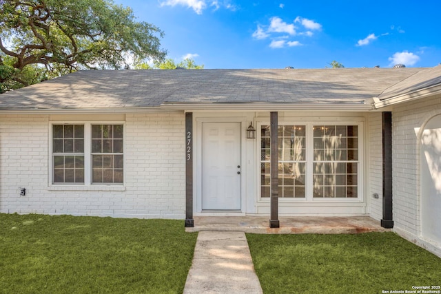 2723 Woodline, San Antonio, TX 78251 - property entrance featuring brick siding, roof with shingles, and a lawn