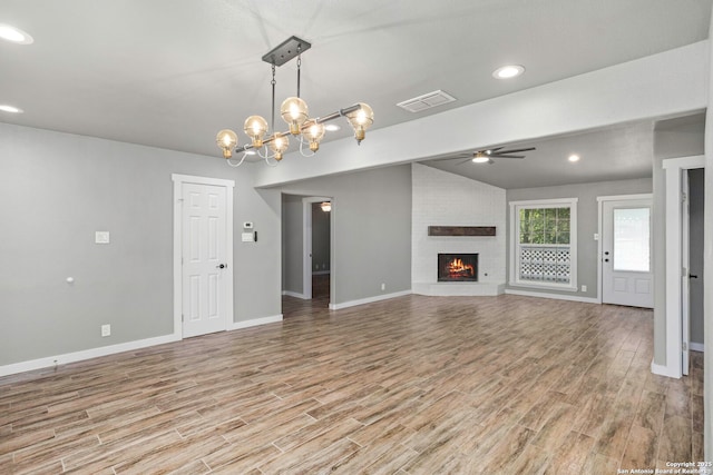 2723 Woodline, San Antonio, TX 78251 - unfurnished living room with a ceiling fan, light wood-style floors, baseboards, a brick fireplace, and vaulted ceiling