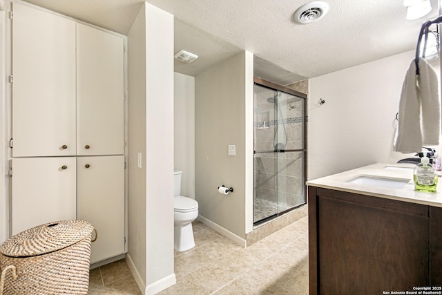 3811 E Songbird Ln, San Antonio, TX 78229 - bathroom featuring toilet, a shower stall, tile patterned floors, vanity, and a textured ceiling