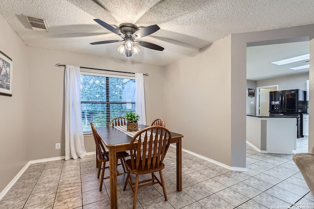 2334 Creekside Bnd, San Antonio, TX 78259 - dining space with light tile patterned flooring, a textured ceiling, a ceiling fan, baseboards, and a skylight