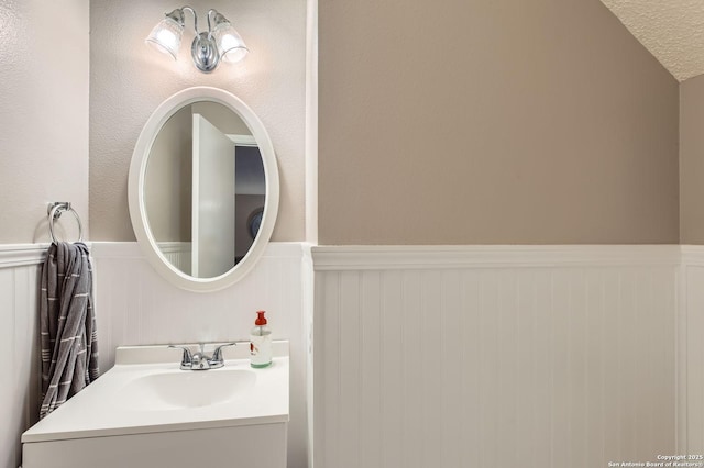 2334 Creekside Bnd, San Antonio, TX 78259 - bathroom with a wainscoted wall, vanity, and a decorative wall