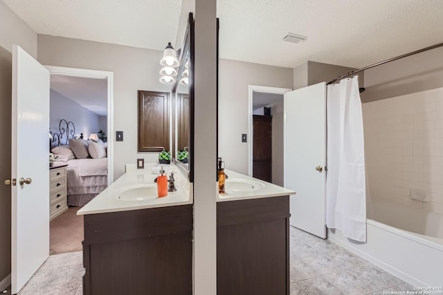 2334 Creekside Bnd, San Antonio, TX 78259 - ensuite bathroom featuring double vanity, shower / bathtub combination with curtain, and a textured ceiling