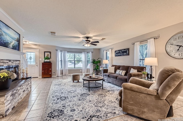 2334 Creekside Bnd, San Antonio, TX 78259 - living area featuring a fireplace, ceiling fan, a textured ceiling, and light tile patterned floors