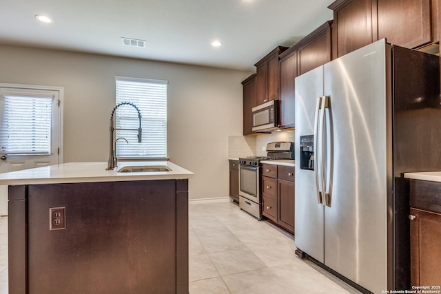 5614 Burr Blf, San Antonio, TX 78266 - kitchen featuring appliances with stainless steel finishes, a sink, healthy amount of natural light, dark brown cabinetry, and recessed lighting