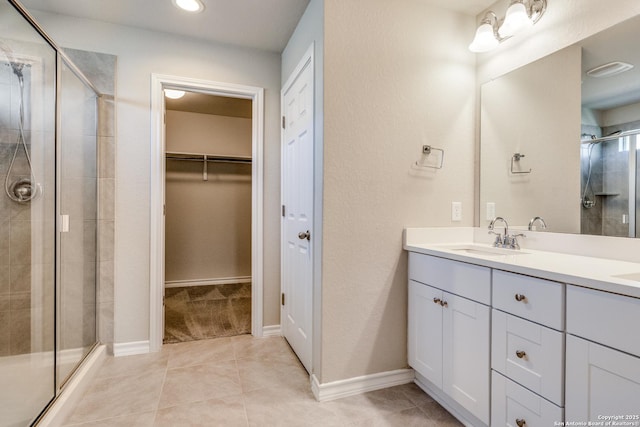 5614 Burr Blf, San Antonio, TX 78266 - full bath featuring double vanity, a shower stall, a spacious closet, tile patterned flooring, and baseboards
