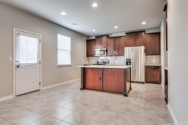5614 Burr Blf, San Antonio, TX 78266 - kitchen featuring stainless steel appliances, backsplash, light countertops, a center island with sink, and recessed lighting