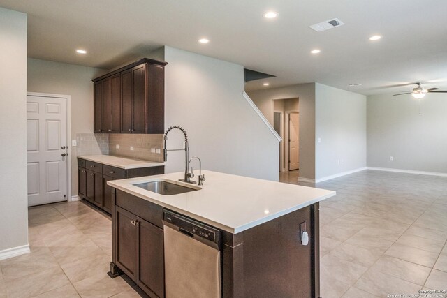 5614 Burr Blf, San Antonio, TX 78266 - kitchen with stainless steel dishwasher, a sink, dark brown cabinetry, a ceiling fan, and a kitchen island with sink