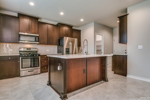 5614 Burr Blf, San Antonio, TX 78266 - kitchen featuring appliances with stainless steel finishes, backsplash, light countertops, an island with sink, and recessed lighting