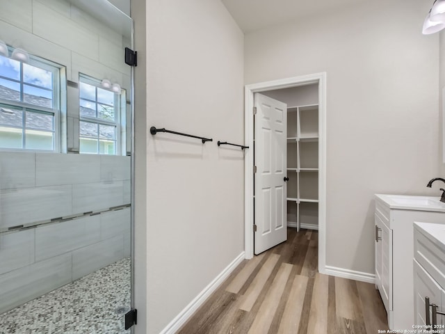8501 Utopia Blvd, Selma, TX 78154 - bathroom with wood finished floors, vanity, a stall shower, baseboards, and a spacious closet