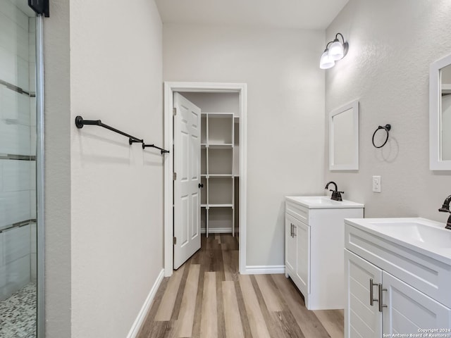 8501 Utopia Blvd, Selma, TX 78154 - full bath featuring wood finished floors, a stall shower, two vanities, and baseboards