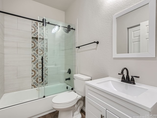 8501 Utopia Blvd, Selma, TX 78154 - full bath featuring a textured wall, bath / shower combo with glass door, toilet, vanity, and wood finished floors